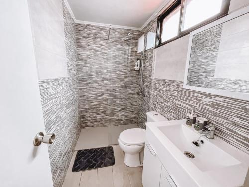 a white bathroom with a toilet and a sink at Dahlia Apartment DunaSol in Corralejo