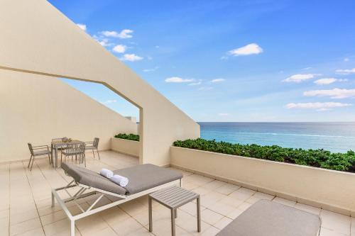 a balcony with a table and chairs and the ocean at Live Aqua Cancun - Adults Only - All-Inclusive in Cancún