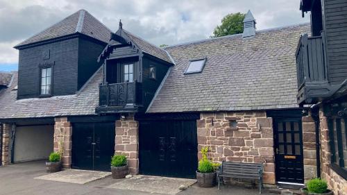 a black house with a bench in front of it at The Art Loft, Crieff: Town Centre Apartment in Crieff