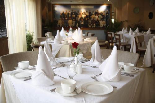 a table with white plates and napkins on it at Ajit Bhawan - A Palace Resort in Jodhpur