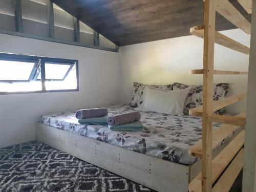 a bedroom with a bunk bed and a ladder at Tupi's Beachfront Home 2BR in Bacungan