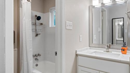a white bathroom with a sink and a mirror at Cozy Efficiency Studios Close to Downtown and Domain in Austin