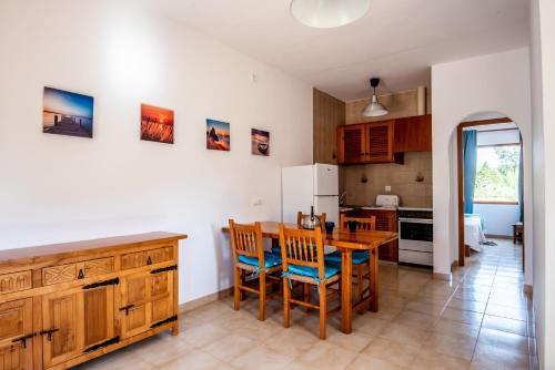a kitchen with a table and chairs and a refrigerator at Aguamar - Emar Hotels in Playa Migjorn
