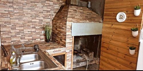 a kitchen with a brick fireplace and a sink at lilie97418 in La Plaine des Cafres