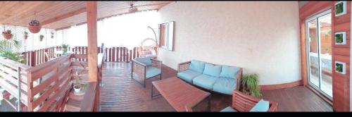 a porch with a couch and chairs on a balcony at lilie97418 in La Plaine des Cafres