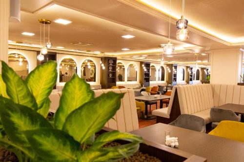 a restaurant with tables and chairs and plants at Admiral Hotel - Ultra All Inclusive & Private Beach in Golden Sands
