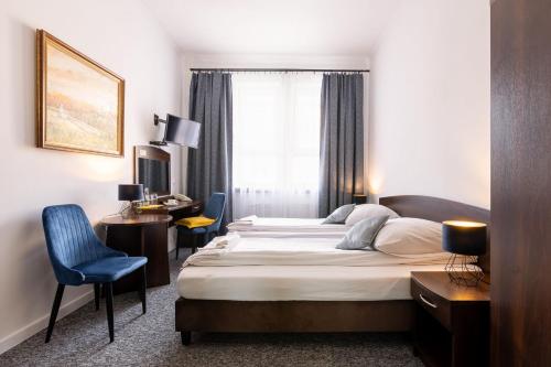 a hotel room with a large bed and a desk at Hotel i Restauracja Nad Jeziorem in Człuchów