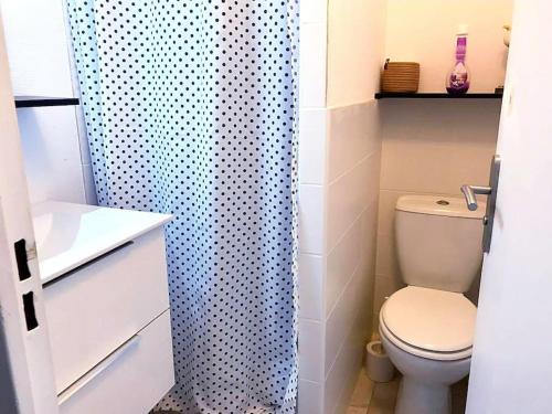een badkamer met een toilet en een blauw douchegordijn bij Résidence Pointe Vermeille - Charmant Studio Cabine avec Jolie vue sur le lac marin in Le Barcarès
