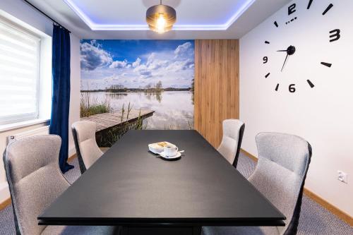 a dining room with a table and a clock on the wall at Hotel i Restauracja Nad Jeziorem in Człuchów