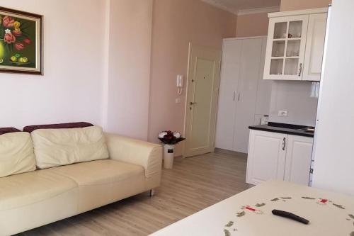 ein Wohnzimmer mit einem weißen Sofa und einer Küche in der Unterkunft Adriatic East View Apartment in Durrës