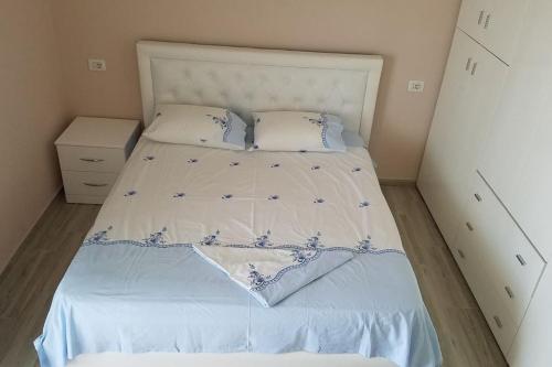 um quarto com uma cama branca com flores azuis em Adriatic East View Apartment em Durrës