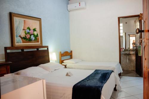 a hotel room with two beds and a mirror at Pousada Adega Cipo in Serra do Cipo