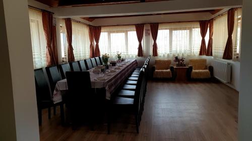 Moigrad的住宿－Vatra Strabunilor，长长的用餐室配有长桌子和椅子