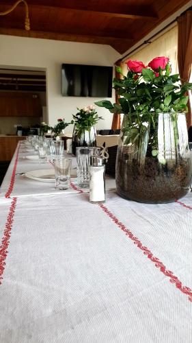 a long table with roses in vases on it at Vatra Strabunilor in Moigrad