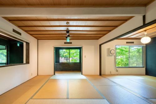 an empty room with a wooden ceiling and windows at 森の宿り 那須別邸まるやま in Nasu