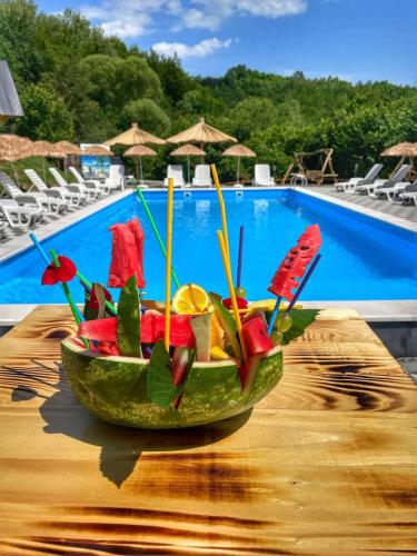 a bowl of fruit on a table next to a pool at Etno Village Dolina Sreće in Vitez