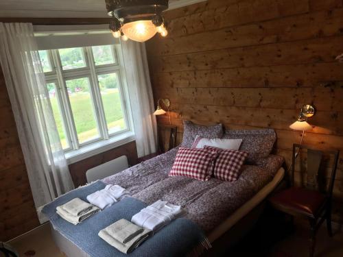 a bedroom with a bed with towels on it at Eide gard in Skjolden