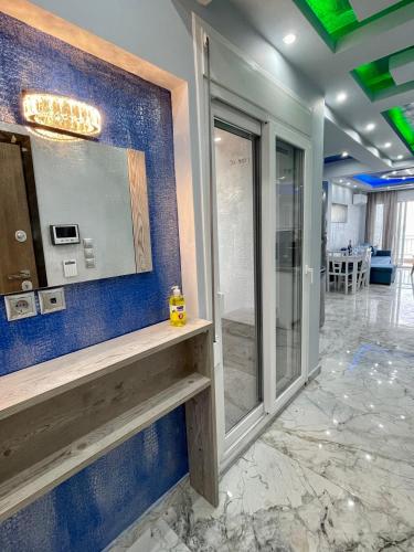 a room with a blue wall with a mirror at CHANIOTH LUXURY SUITES BY MAKHOME in Hanioti