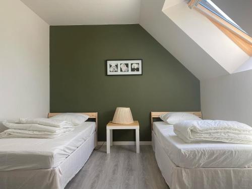 - 2 lits dans une chambre dotée d'un mur vert dans l'établissement Maison calme familiale proche plages, à Erquy