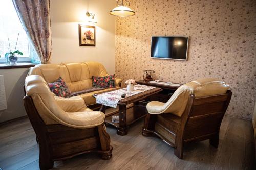 a waiting room with a couch and chairs and a table at Kalvín Restaurant & Pension in Rastislavice