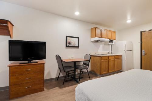a small room with a bed and a small table with a television at WoodSpring Suites Houston I-45 Airtex in Houston