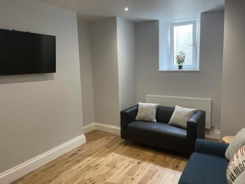 Great 2 bedroom flat في بلايموث: غرفة معيشة مع أريكة وتلفزيون بشاشة مسطحة