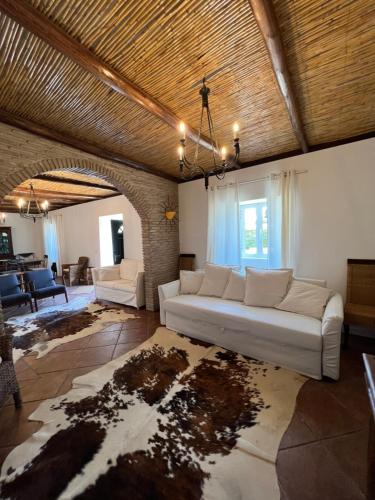 a living room with a white couch and a table at Monte do Tesoureiro in São Brás de Alportel