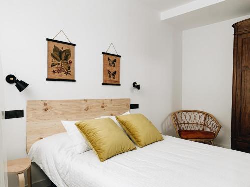 a bedroom with a bed with white sheets and yellow pillows at Estudio 33 in San Juan de la Arena