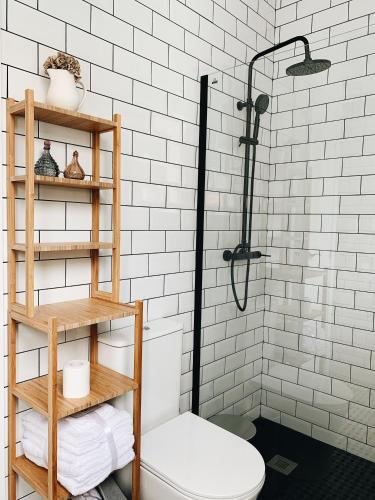 a white bathroom with a shower and a toilet at Estudio 33 in San Juan de la Arena