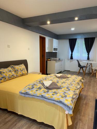 1 dormitorio con cama amarilla, mesa y sillas en Apartments Lalović, en Žabljak