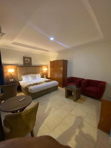 a hotel room with a bed and a red couch at ديوان اليمامة للشقق المخدومة in Taif