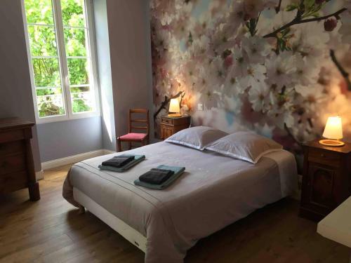 a bedroom with a bed with a floral wall at Entre Vignobles et Estuaire - Gîte 12 pers in Saint-Thomas-de-Cônac