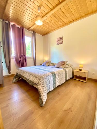 une chambre avec un lit et un plafond en bois dans l'établissement Gîte AXALY Gorges de l'Ardèche, à Saint-Just