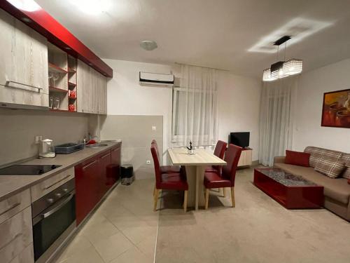 a kitchen and living room with a table and chairs at Holiday Wing Apartments in Jagodina
