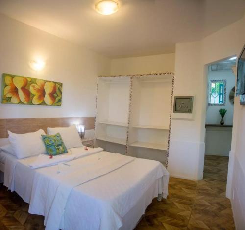 a bedroom with two beds with white sheets and a window at Solar das Orquídeas in Porto Seguro