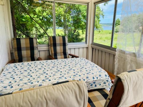 a table and chairs in a room with windows at Villa Rönnhagen in Glava