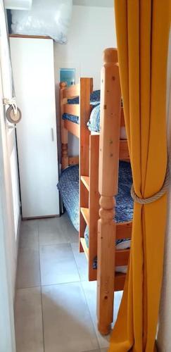 Cette chambre dispose de lits superposés et d'un couloir avec une porte. dans l'établissement Résidence Pointe Vermeille - Charmant Studio Cabine avec Jolie vue sur le lac marin, au Barcarès