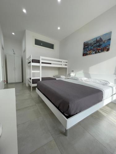 een slaapkamer met een groot bed in een witte kamer bij Terrazza Don Mario bed&breakfast in Pozzuoli