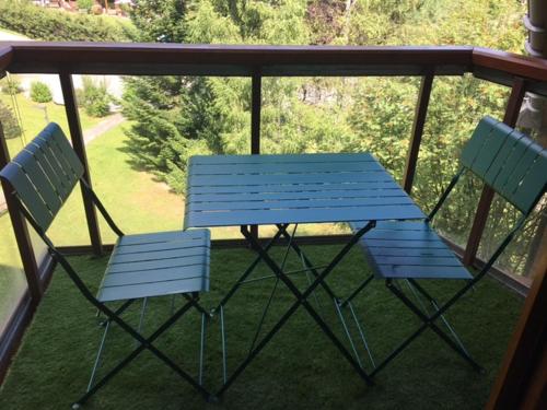 2 chaises et un banc bleu sur une terrasse couverte dans l'établissement L'enclaves, aux Contamines-Montjoie