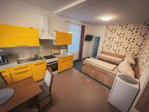 a kitchen with yellow cabinets and a couch in a room at Hotel Apartment Faraon in Rumburk