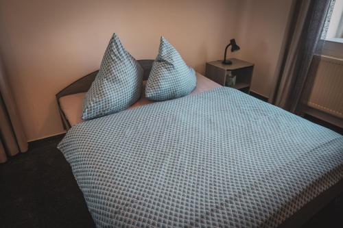 a bedroom with a bed with blue sheets and pillows at Hotel Apartment Faraon in Rumburk