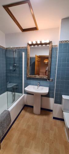 y baño con lavabo, ducha y espejo. en Casa Mon, en Tiurana