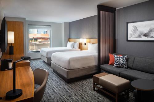 a hotel room with two beds and a couch at Hyatt Place Nashville Downtown in Nashville