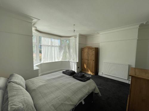 um quarto com uma cama e uma janela em 3 bedroom Garden apartment next to craig-y-don park em Llandudno