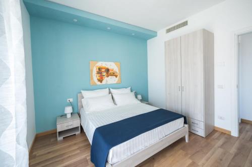 1 dormitorio azul con 1 cama con pared azul en Stampeggioni Appartamenti, en Anzio