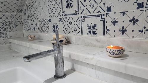 a bathroom with a sink with a candle in it at Maison Bleu in Hammamet