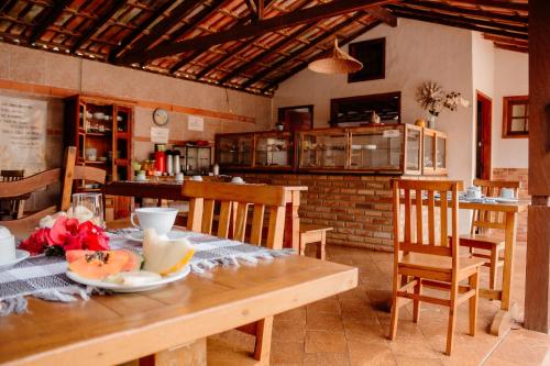 a dining room with a table and chairs and a kitchen at Pousada Adega Cipo in Serra do Cipo