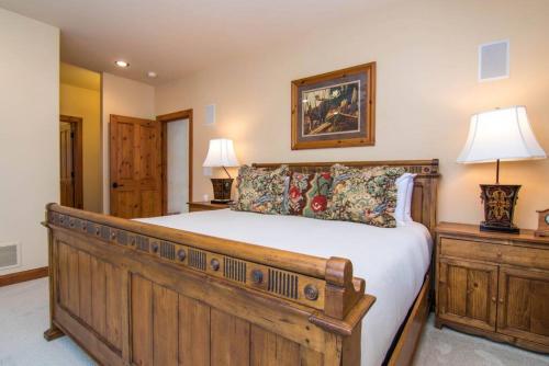 a bedroom with a wooden bed and two lamps at Mountainside Manor with Hot Tub in Edwards