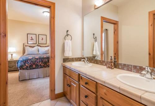 a bathroom with two sinks and a bedroom with a bed at Mountainside Manor with Hot Tub in Edwards