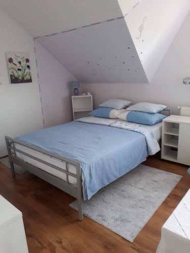 een slaapkamer met een bed met blauwe lakens en blauwe kussens bij Apartman Breza in Zagreb